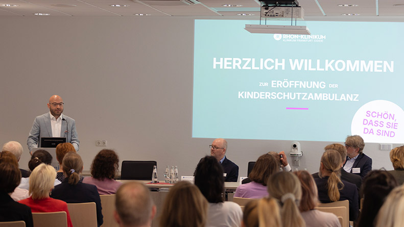 Ein Mann hält eine Rede vor Publikum zur Eröffnung der Kinderschutzambulanz